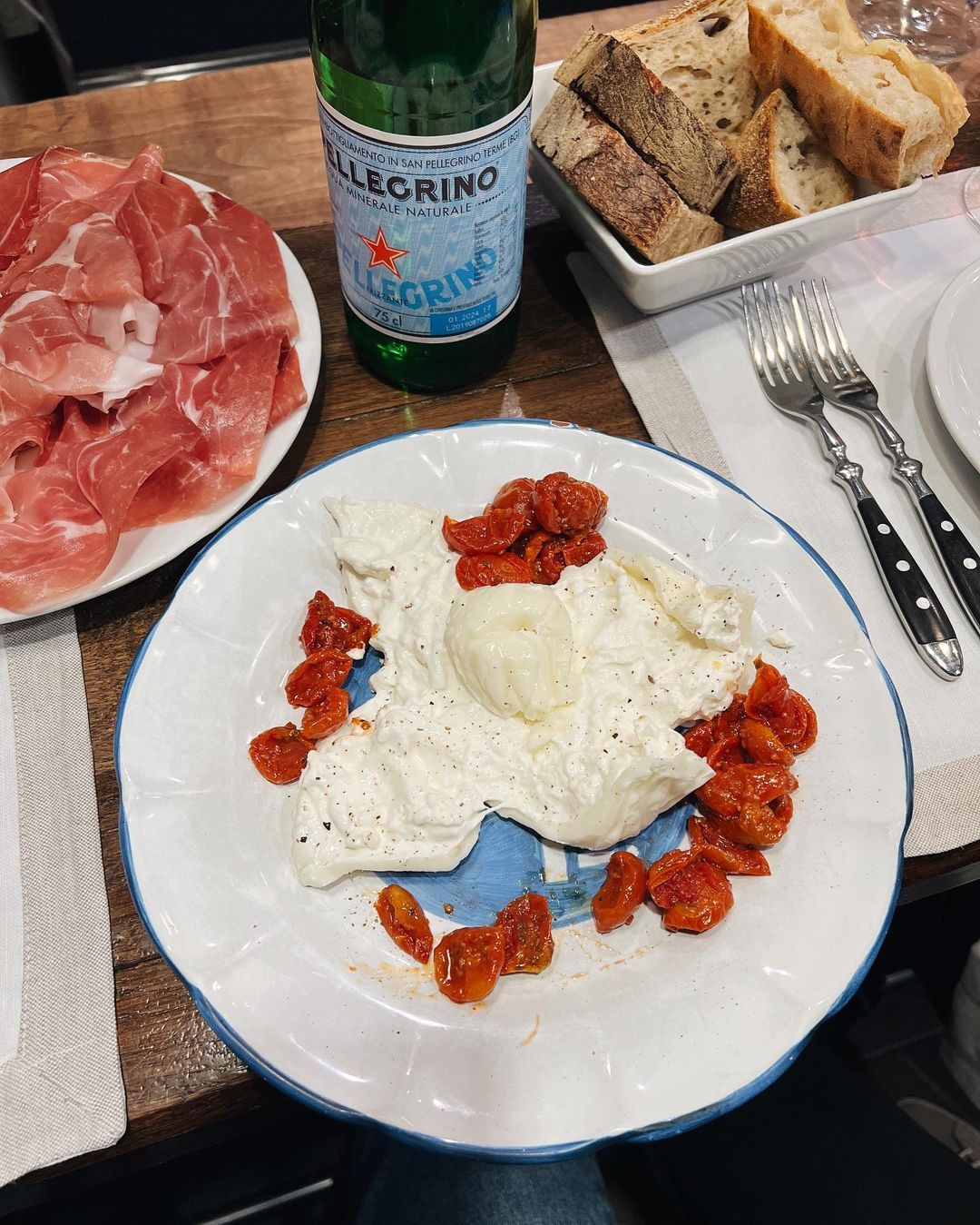 an image of an opened burrata on a place with sun dried tomatoes