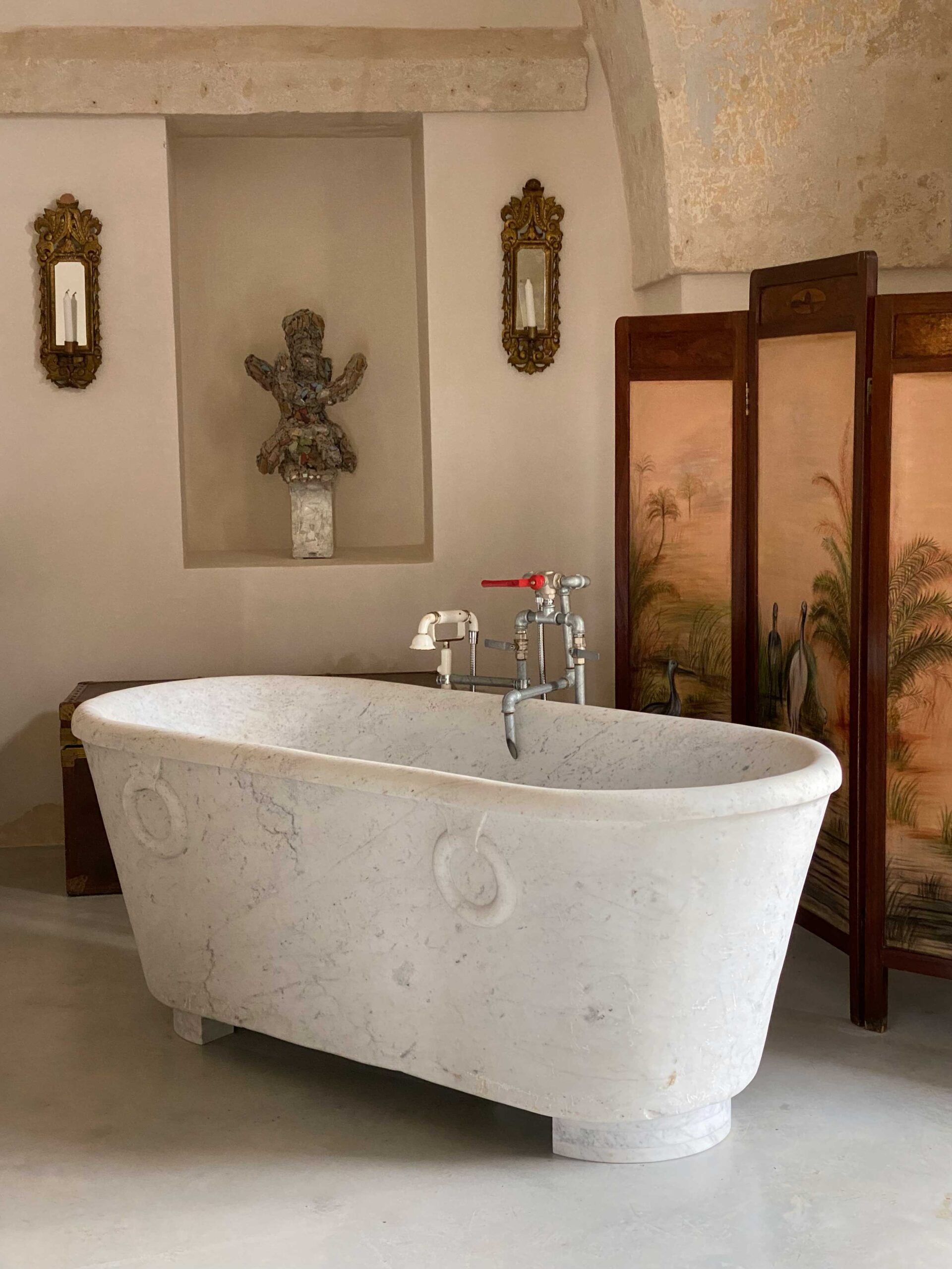 an image of a deep, marble, standalone bathtub in Masseria Schiuma