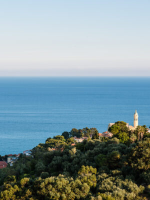 an image of Bussana Vecchia taken from afar looking down at the small village on a hilltop by the sea