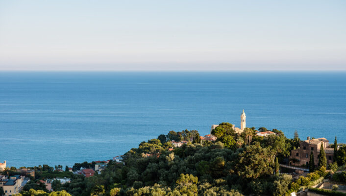 an image of Bussana Vecchia taken from afar looking down at the small village on a hilltop by the sea