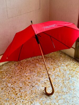 an image of a bright red umbrella open and lying on the ground