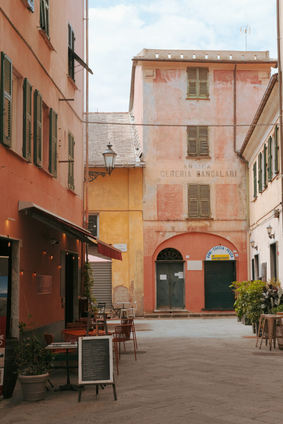 an image of an empty street in chiavari with the empty tables of a few restaurants out front