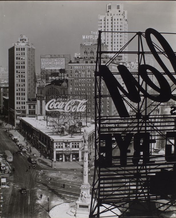 a black and white vintage photo of Columbus Circle, Manhattan shot through the coca cola sign
