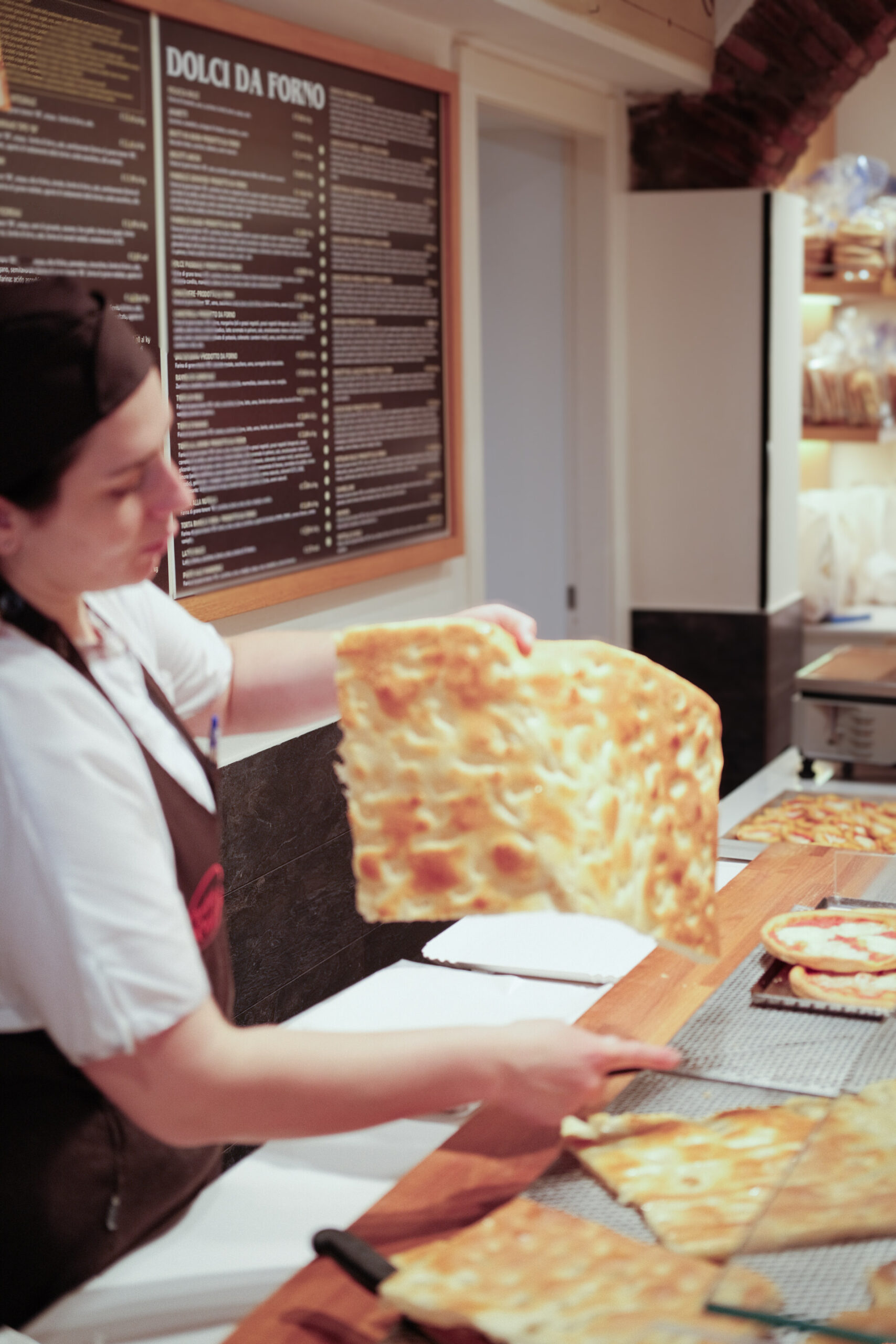 an image of a woman holding a piece of focaccia