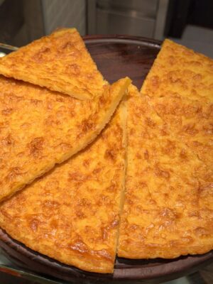 a close up image of triangles of farinata in a round serving dish