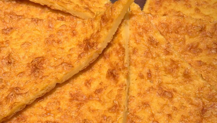 a close up image of triangles of farinata in a round serving dish