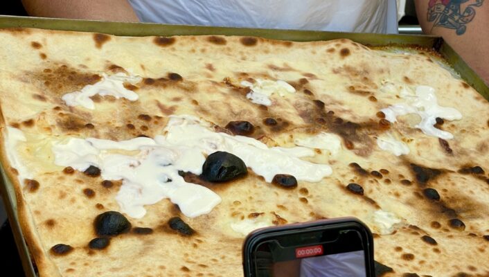 an image of a tray of Focaccia di Recco with oozing cheese out the top