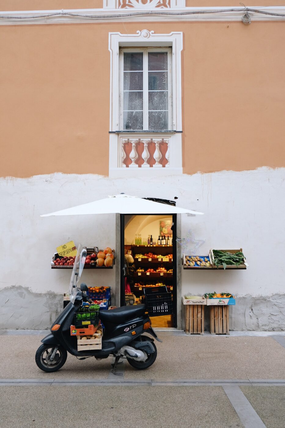 an image of a small fruttivendolo in Levanto with a vespa parked out front