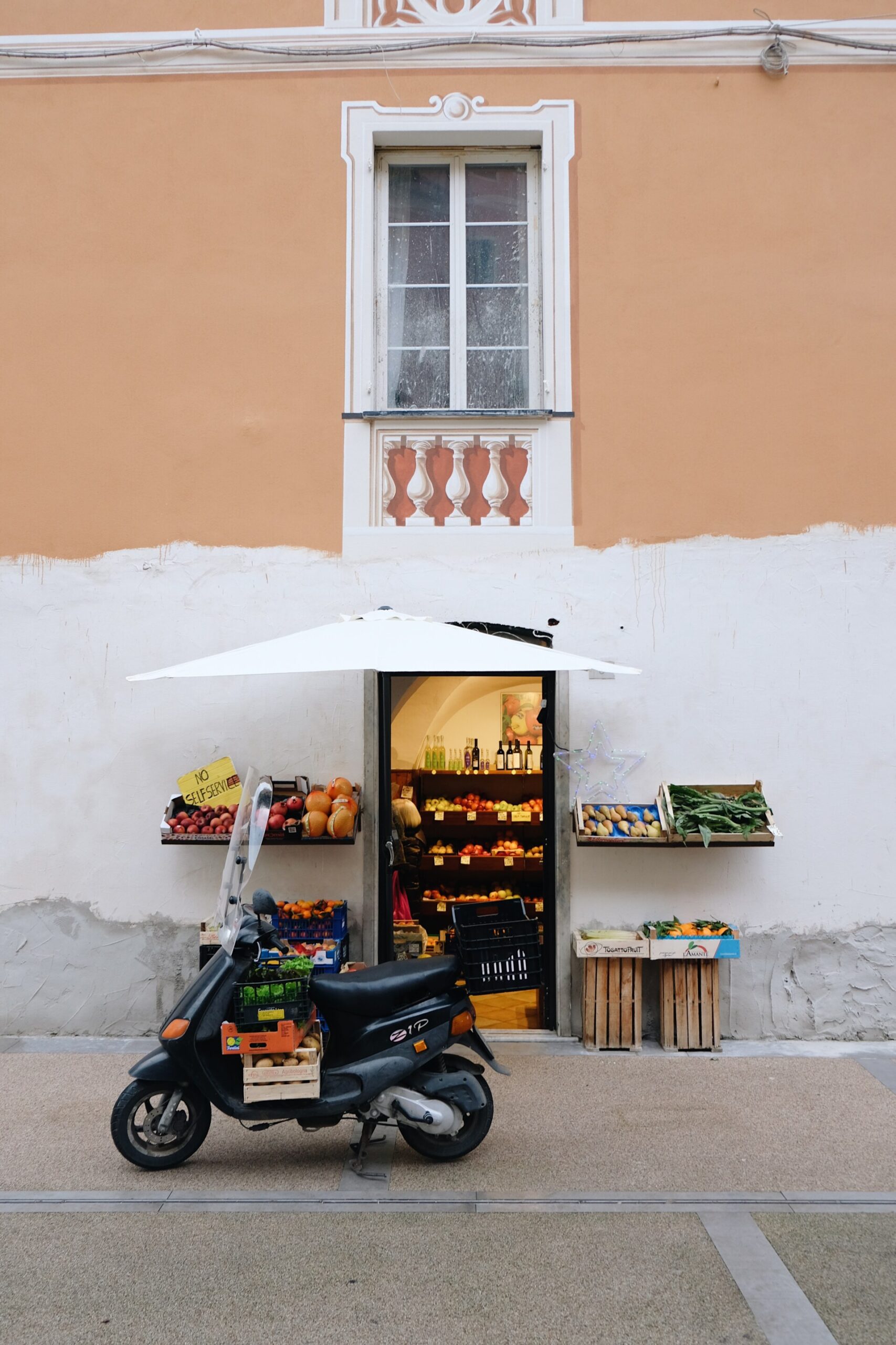 an image of a small fruttivendolo in Levanto with a vespa parked out front
