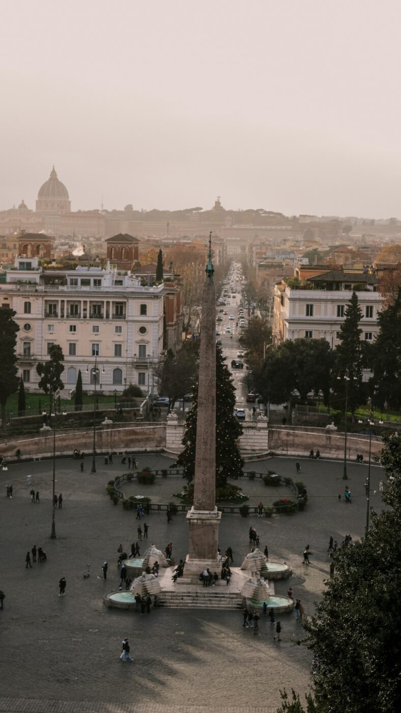 an image of piazza del popolo taken from Villa Borgese looking into the Vatican in the distance with a Christmas tree in the piazza
