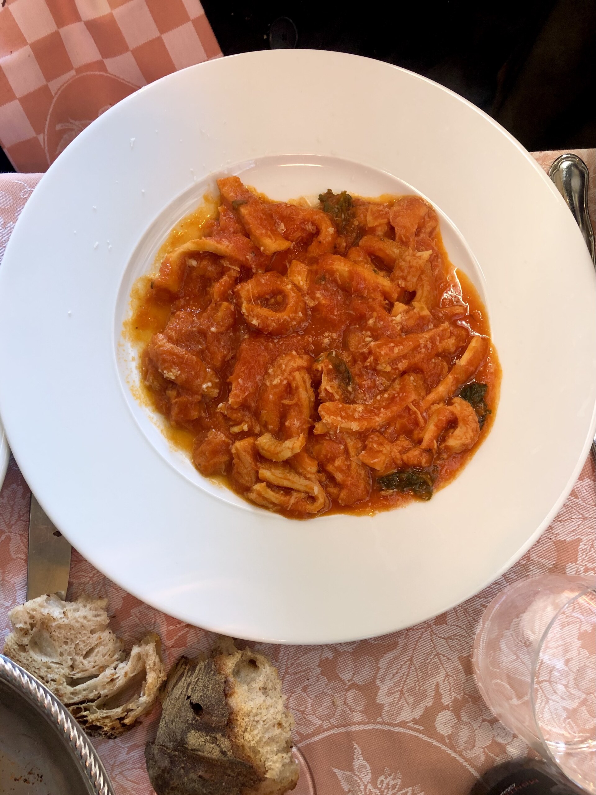 an overhead image of trippa alla romana, thinly sliced tripe in a red tomato sauce