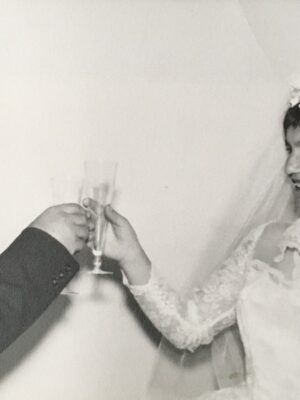a vintage black and white image of a couple cheering on their wedding day