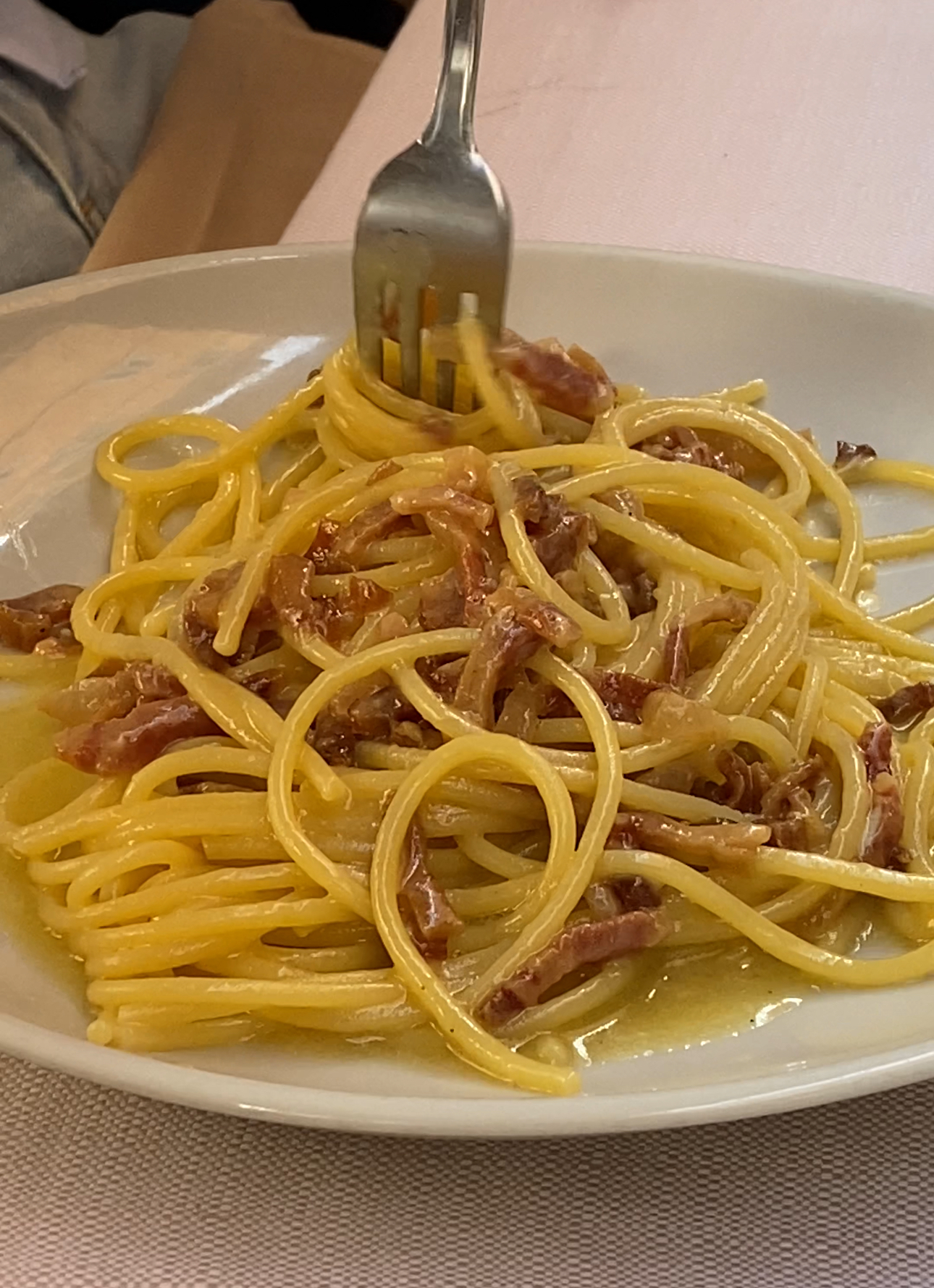 an image of a fork twirling spaghetti carbonara