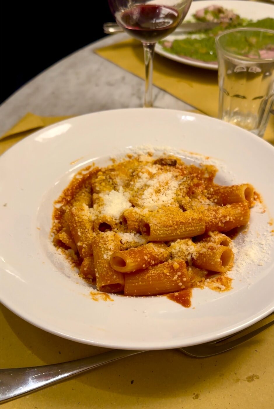 a dish of rigatoni con la pajata with pecorino on top