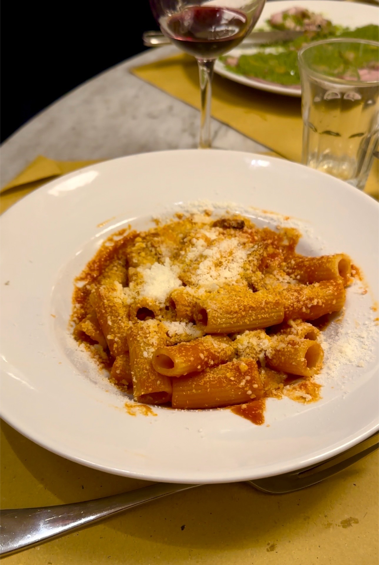 a dish of rigatoni con la pajata with pecorino on top