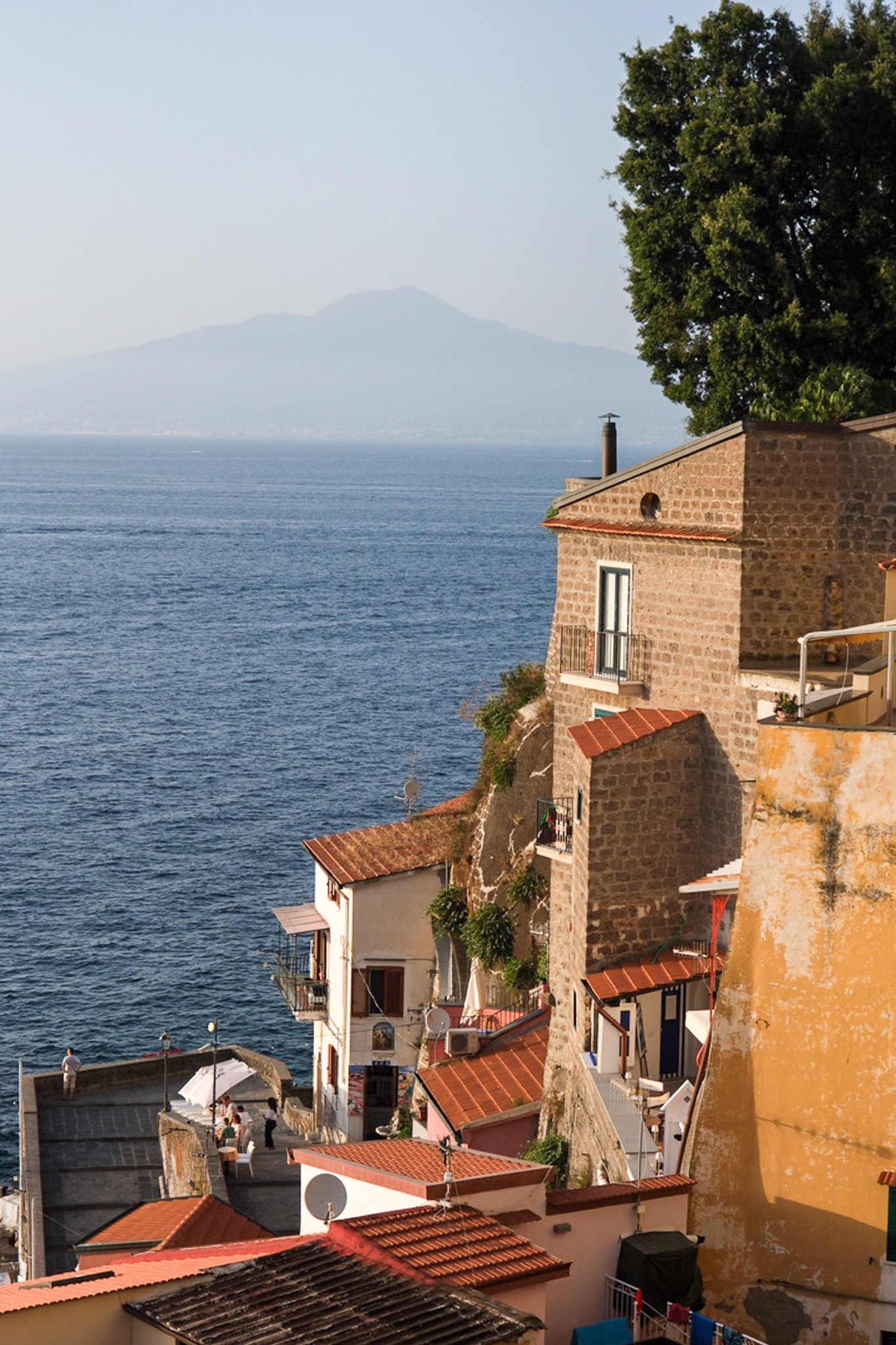 the marina grande in sorrento with houses cascading down into the sea in front of Vesuvius