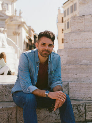 an image of Amir sitting on the side of a fountain
