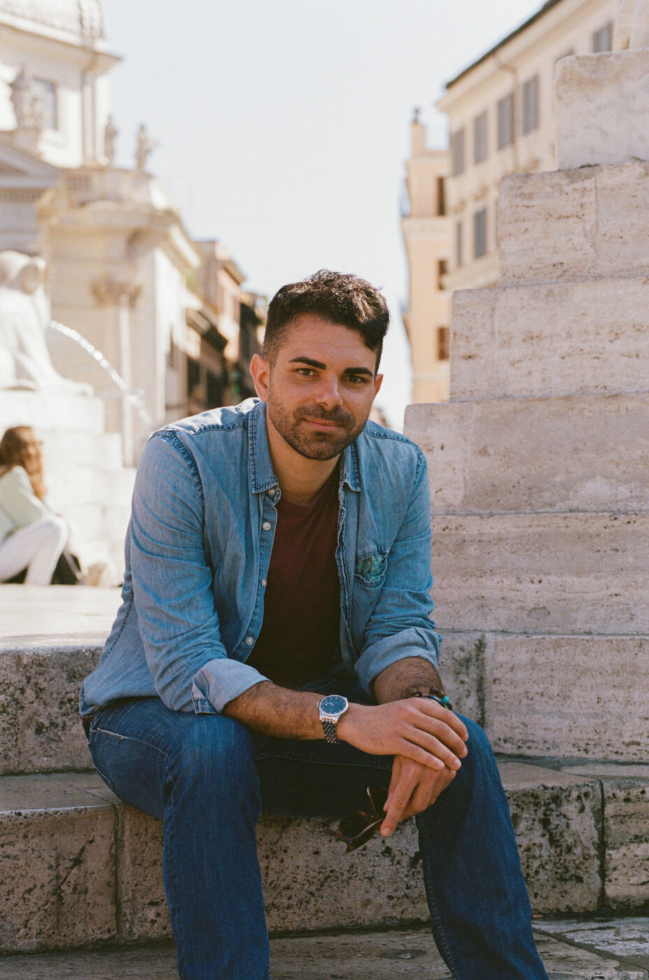 an image of Amir sitting on the side of a fountain