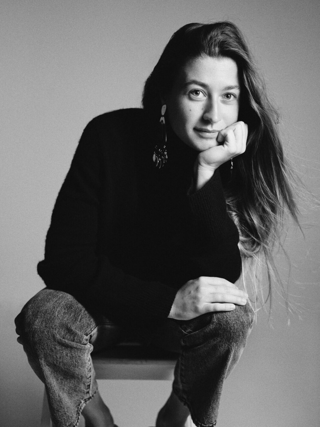 a black and white image of annagreta panconesi sitting and leaning her head on her chin