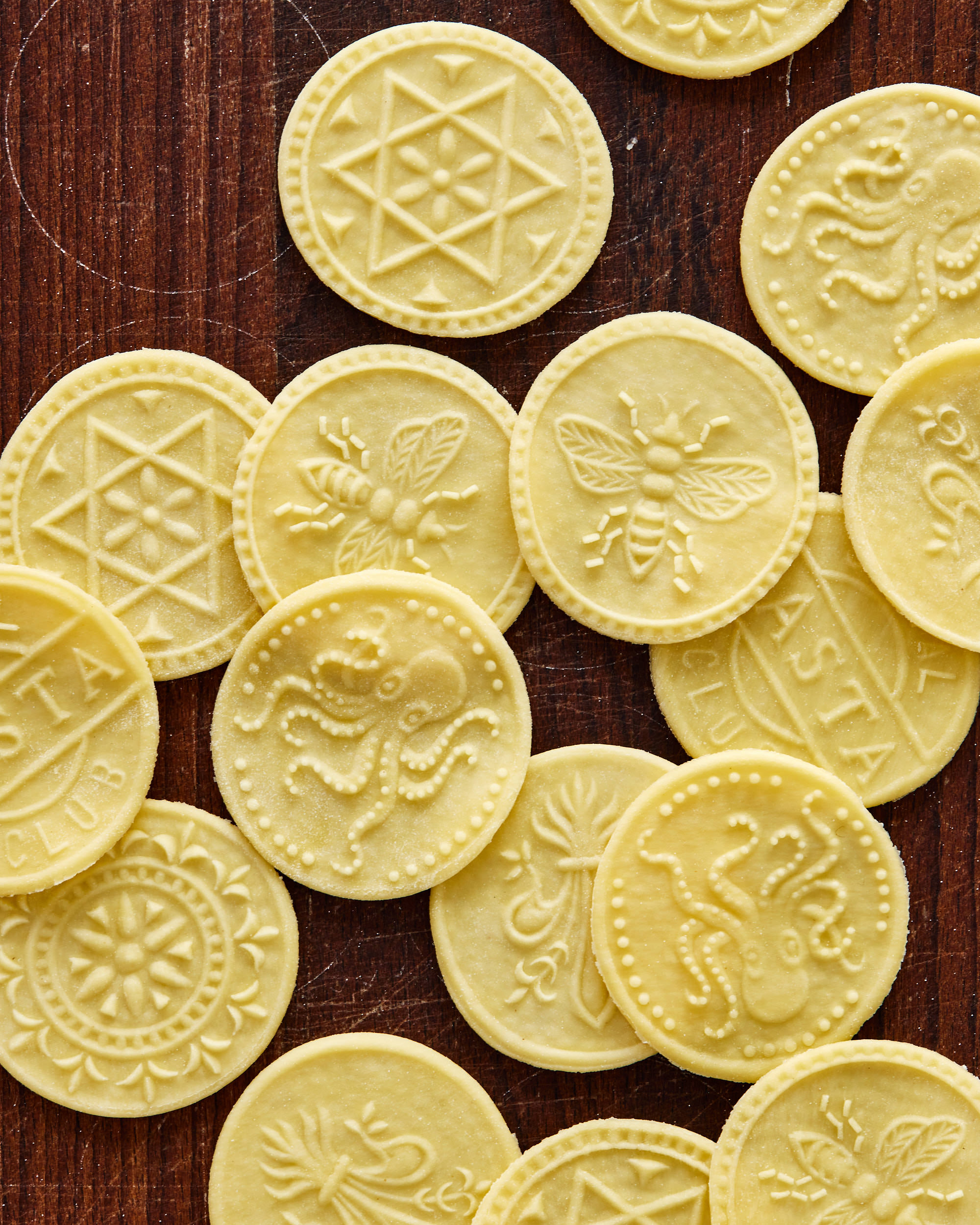 an image of circular corzetti pasta with octopus, bees, and shapes stamped into them