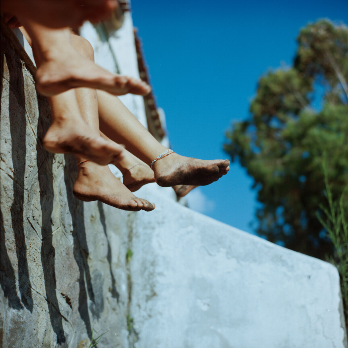 an image of legs dangling over a wall