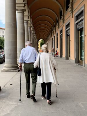 an elderly couple walking away under a covered walkway