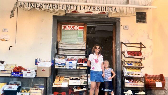 a vintage image of a mom and her daughter in front of an alimentari