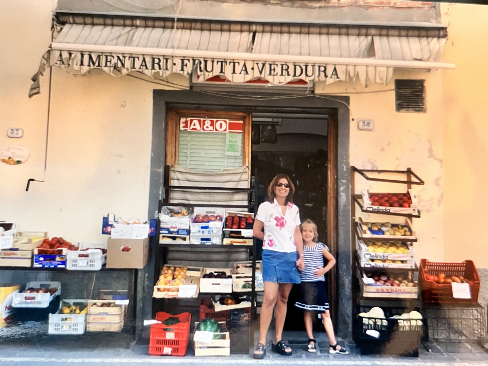 a vintage image of a mom and her daughter in front of an alimentari