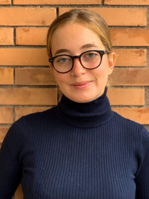 An image of Laura De Dilectis with glasses and a navy turtleneck