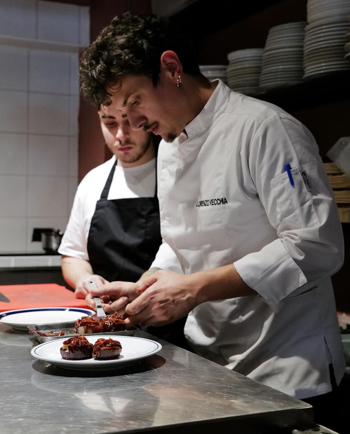 an image of chef Lorenzo Vecchia preparing a dish at his Bologna restaurant