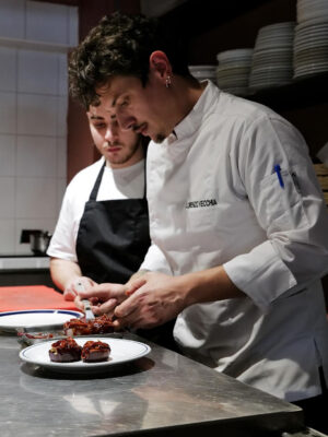 an image of chef Lorenzo Vecchia preparing a dish at his Bologna restaurant