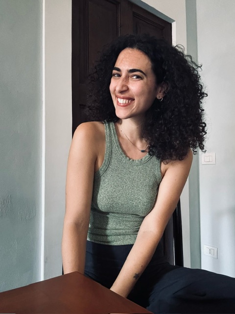 an image of viola stancati sitting in a green tank top at a kitchen table
