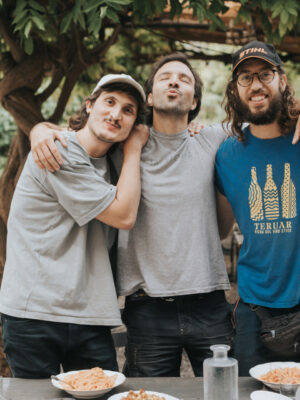 three young guys hugging and standing in front of their agriturismo