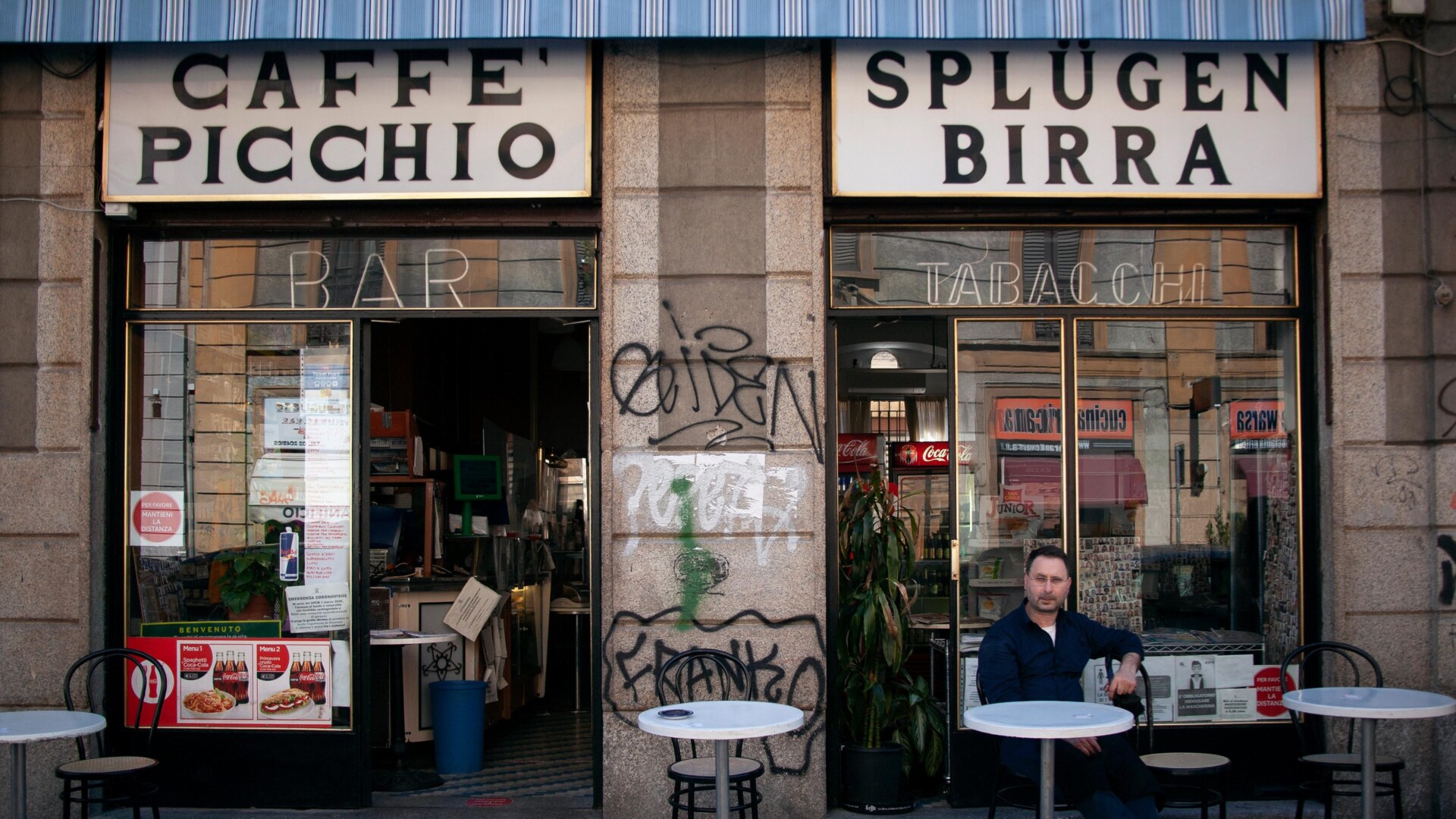 the facade of Caffè Picchio in Milan with a man sitting out front