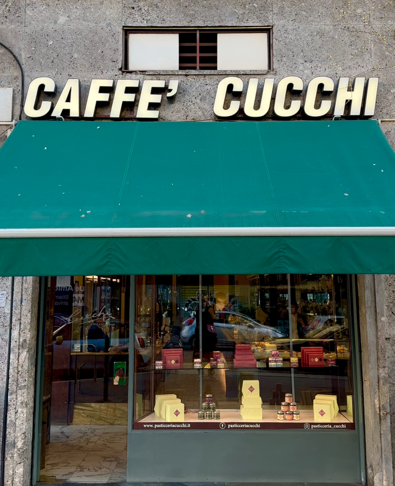 the facade of Pasticceria Cucchi with a green awning and bold white lettering