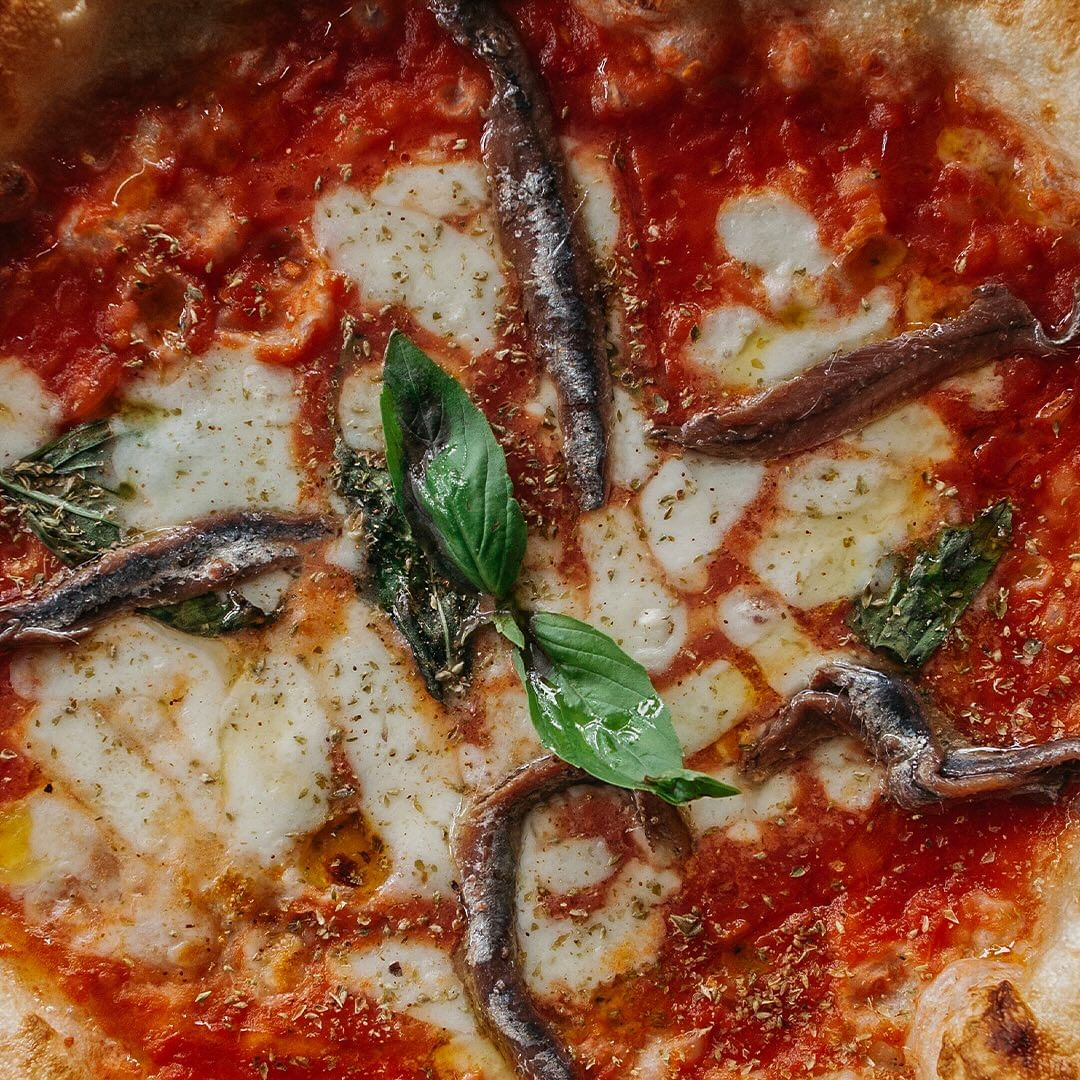 a close up image of a pizza with anchovies from song' e napule