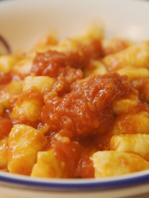 a bowl of gnocchi with tomato sauce