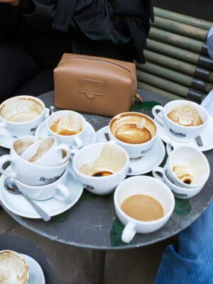 a bunch of empty coffee cups with an atp atelier leather bag on a small table at il caffe in stockholm