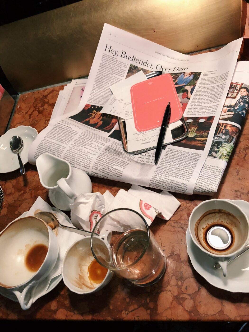 a pile of empty espresso cups and a newspaper at Sant Ambroeus