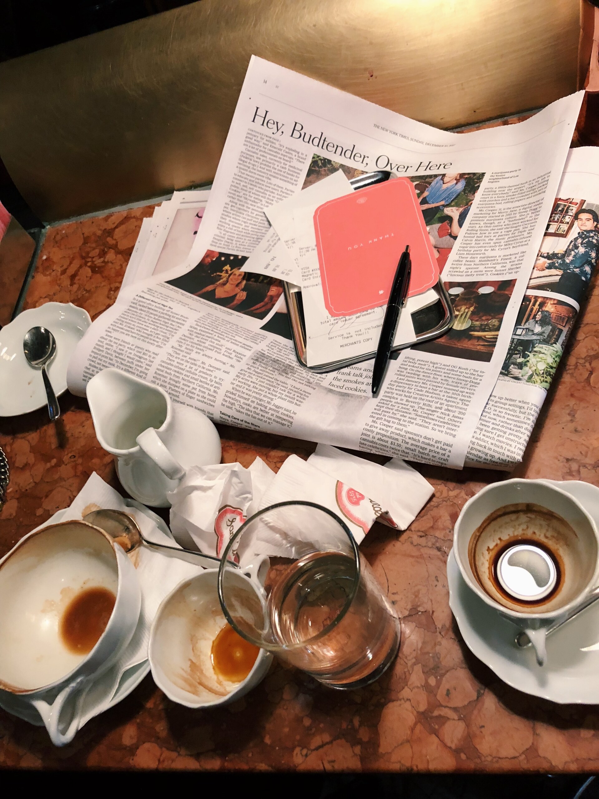 a pile of empty espresso cups and a newspaper at Sant Ambroeus