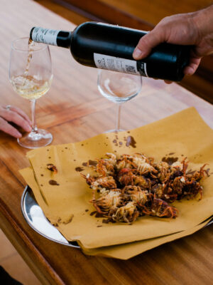 a plate of Moeche Fritti with a glass of red wine