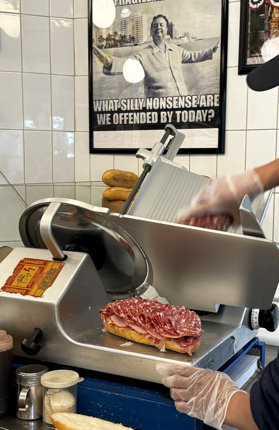 an image of someone slicing meat onto a sandwich at Faicco's Italian Deli