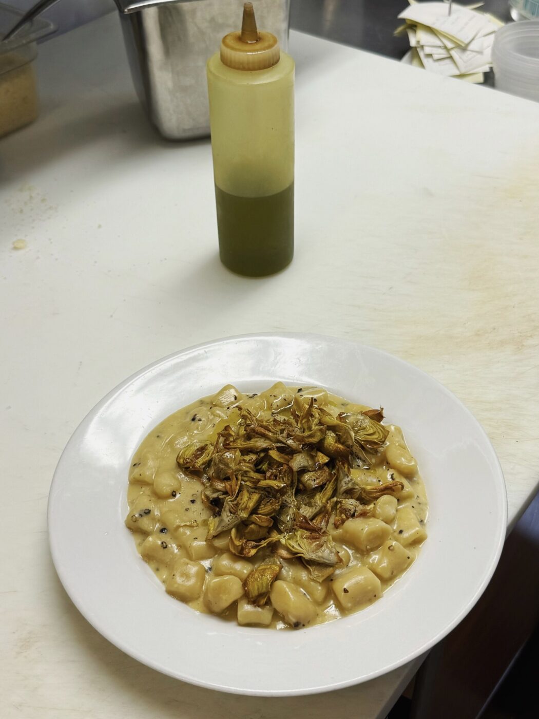 a plate of gnocchi in the kitchen at il posto accanto