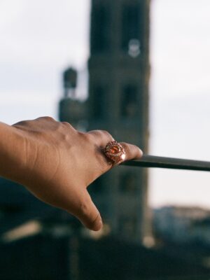 a large ring on a woman's hand outstretched with Florence in the background