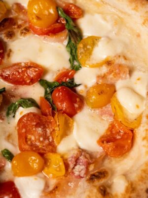 pizza from starita in naples with datterino cherry tomatoes, Pecorino Romano, garlic, oregano, pepper, and basil