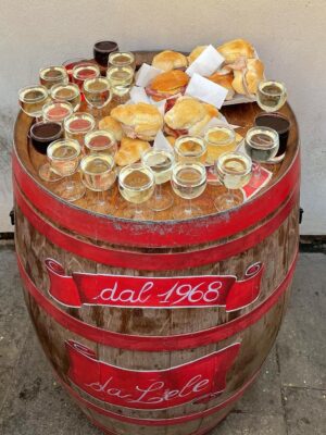 a barrel filled with small glasses of wine and little cicchetti sandwiches at a bar in Venice