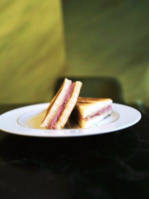 a perfect toast with ham and cheese sliced into triangles on a plate
