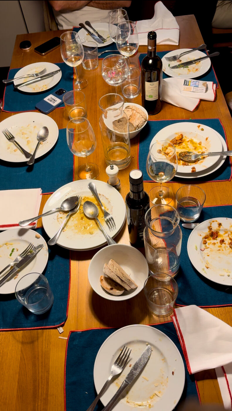 an image of a table mid dinner with lots of plates and food