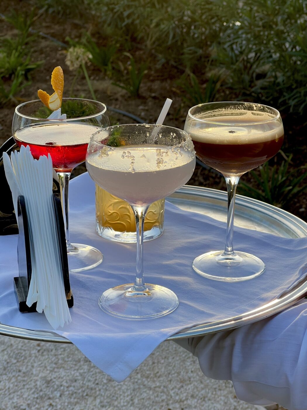 three martinis on a tray being carried out by a waiter