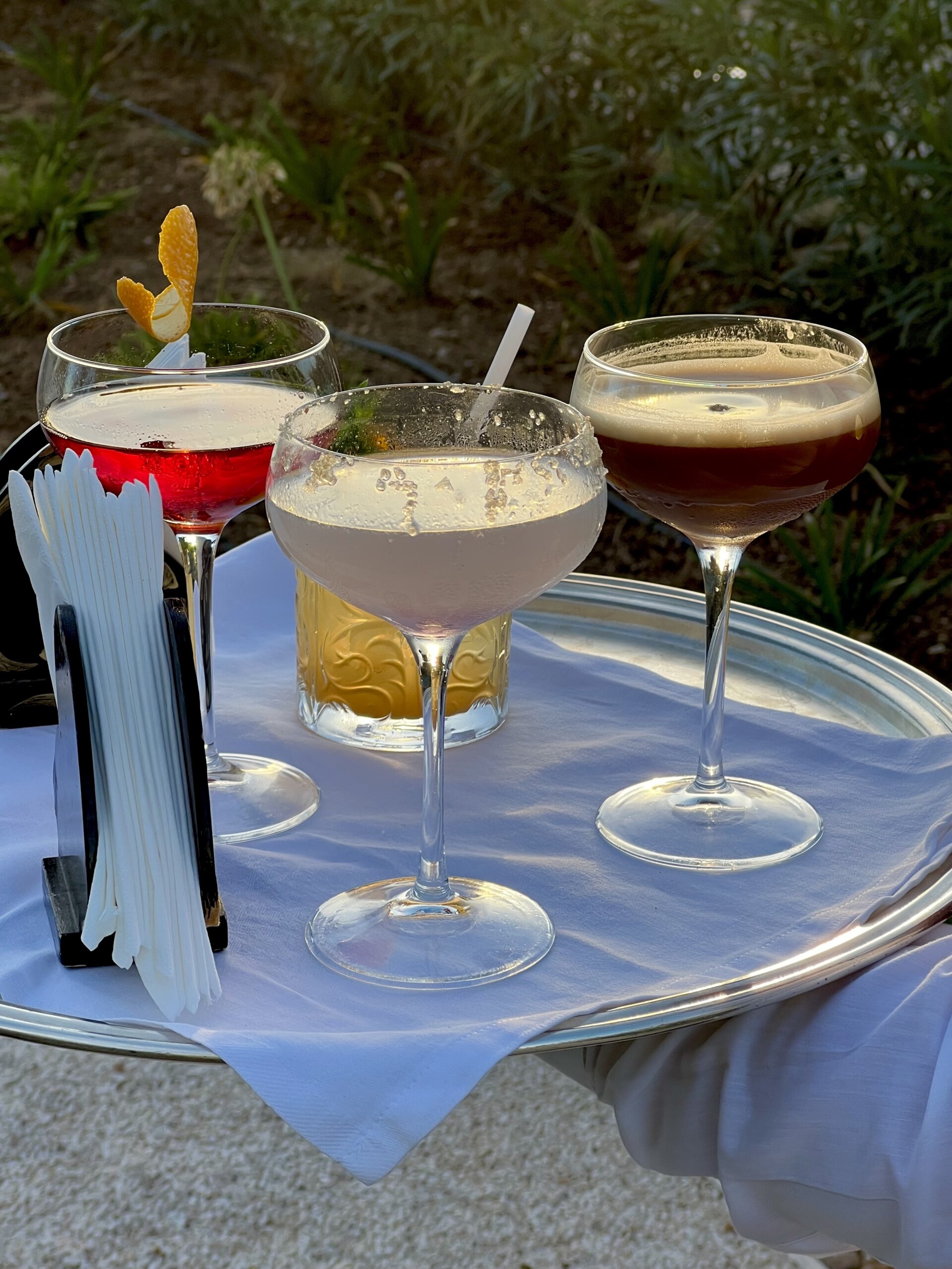 three martinis on a tray being carried out by a waiter